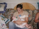 Auntie sitting on the couch feeding Anna